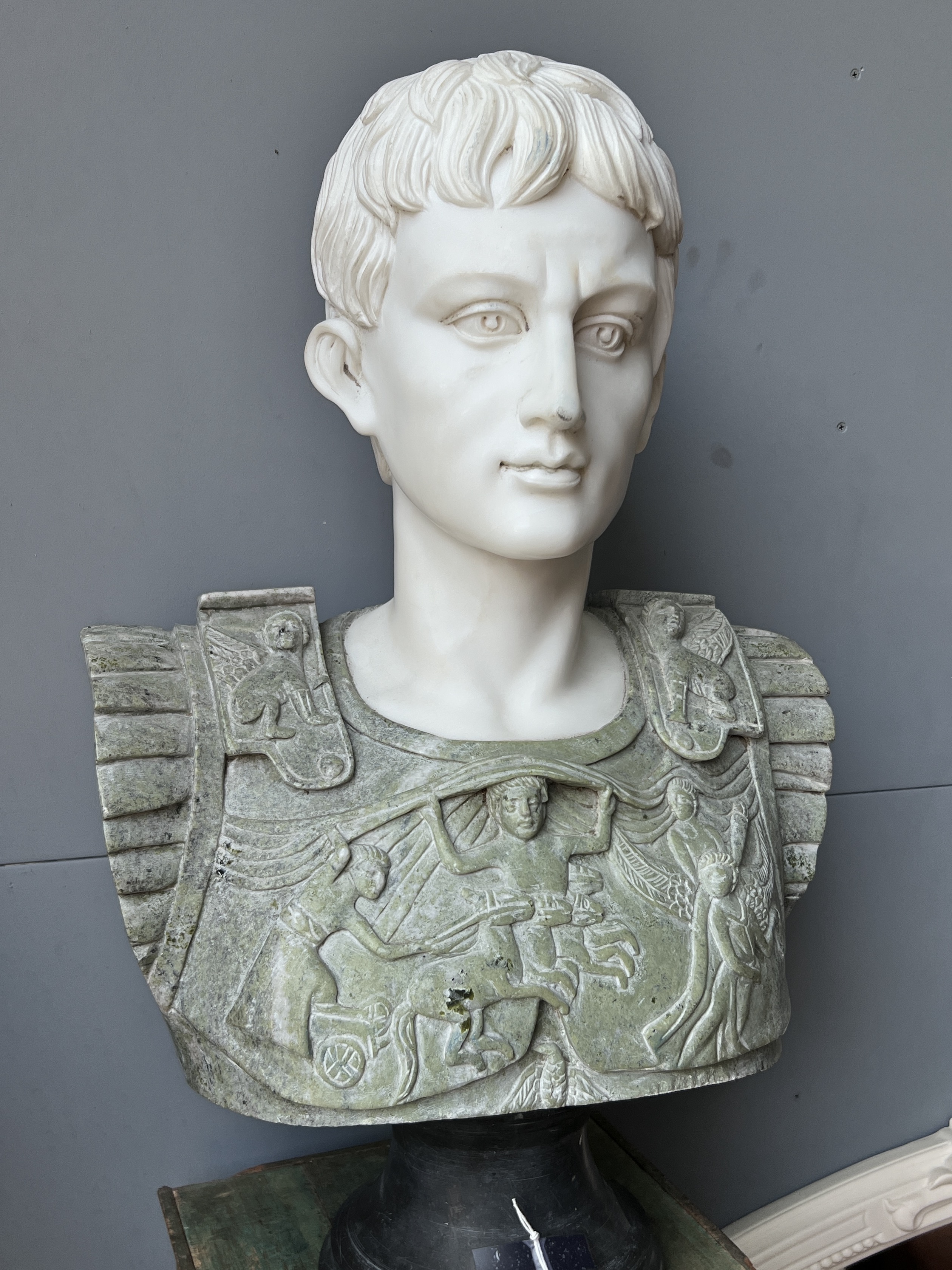 A reconstituted marble bust of a Roman emperor on painted wood plinth, total height 170cm